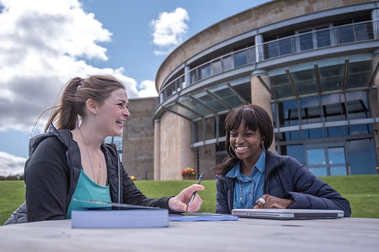 Students sitting outside School of Management